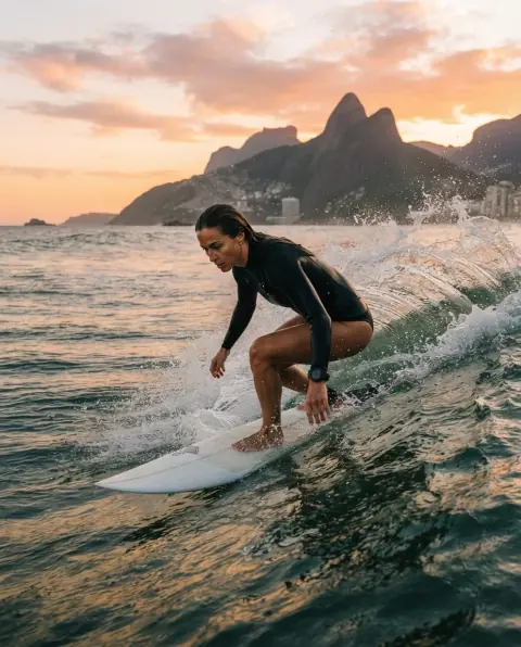 Surfista pegando onda no Arpoador ao amanhecer